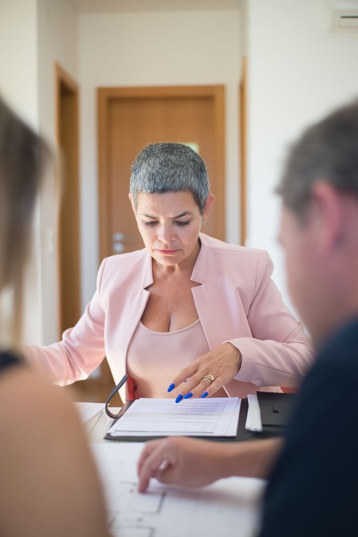 Professional woman reviewing documents during a business meeting indoors.